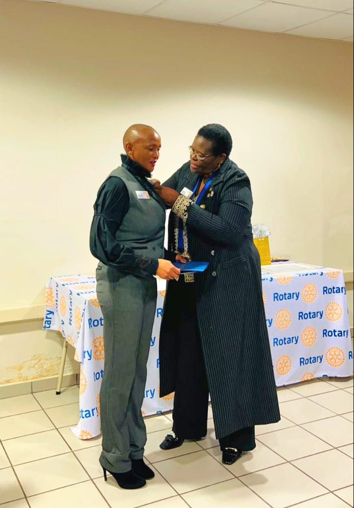 Rotary E-Club of Baobab President Phuti Ragophala attaching the Pin of Paul Harris Fellow award